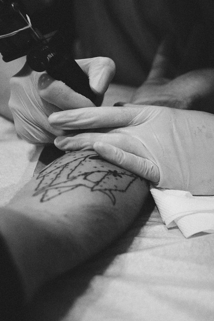 Grayscale Photography of Person Holding Tattoo Machine